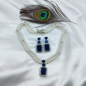 Elegant pearl necklace set with blue stones and matching earrings on satin fabric with peacock feather – Radiantjewels.store